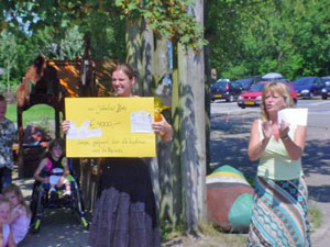 jonge vrouw staat met een cheque ter waarde van 4000 euro in haar hand